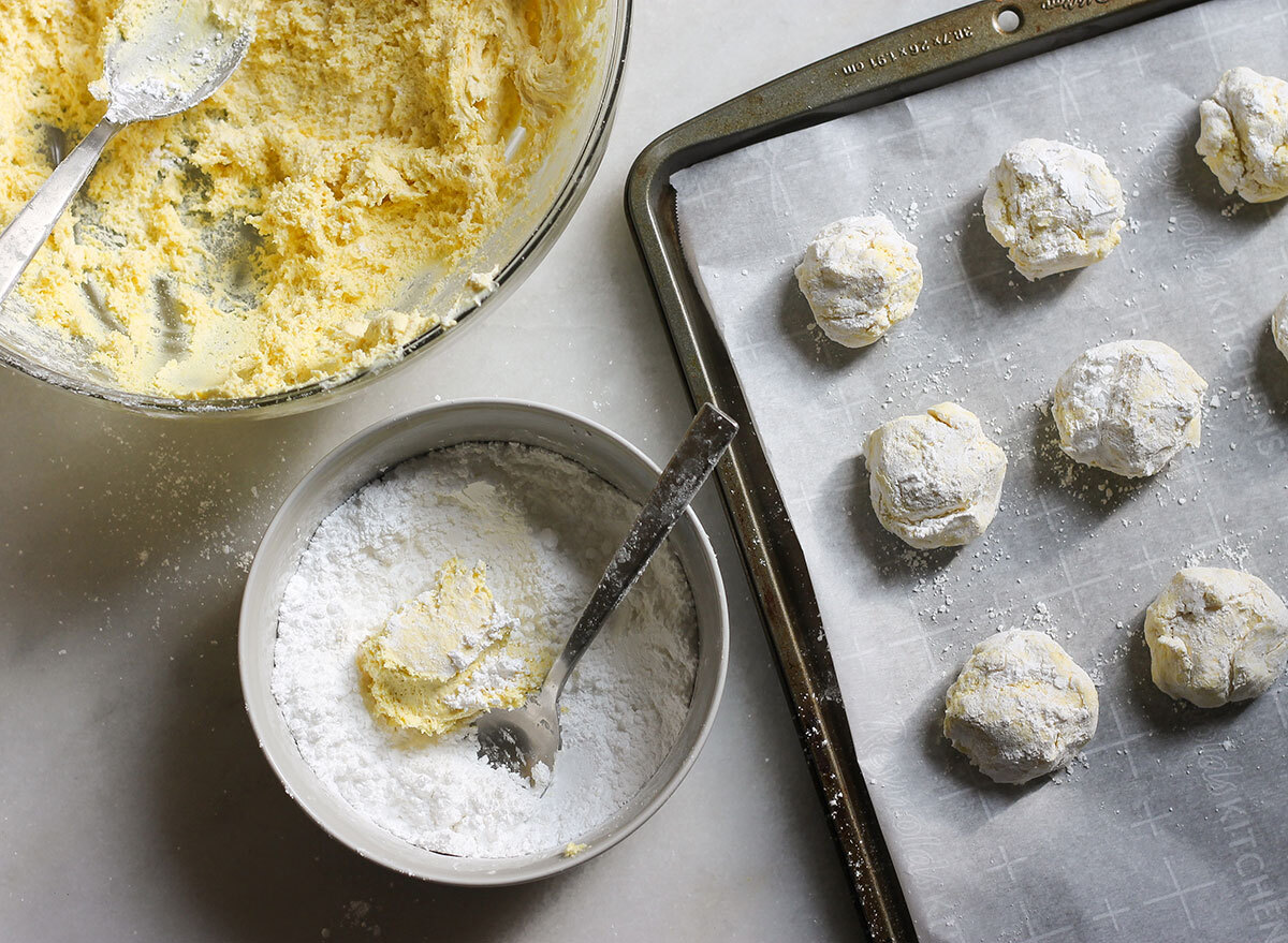 mixing cake cookie recipes with powdered sugar and placing on a baking sheet