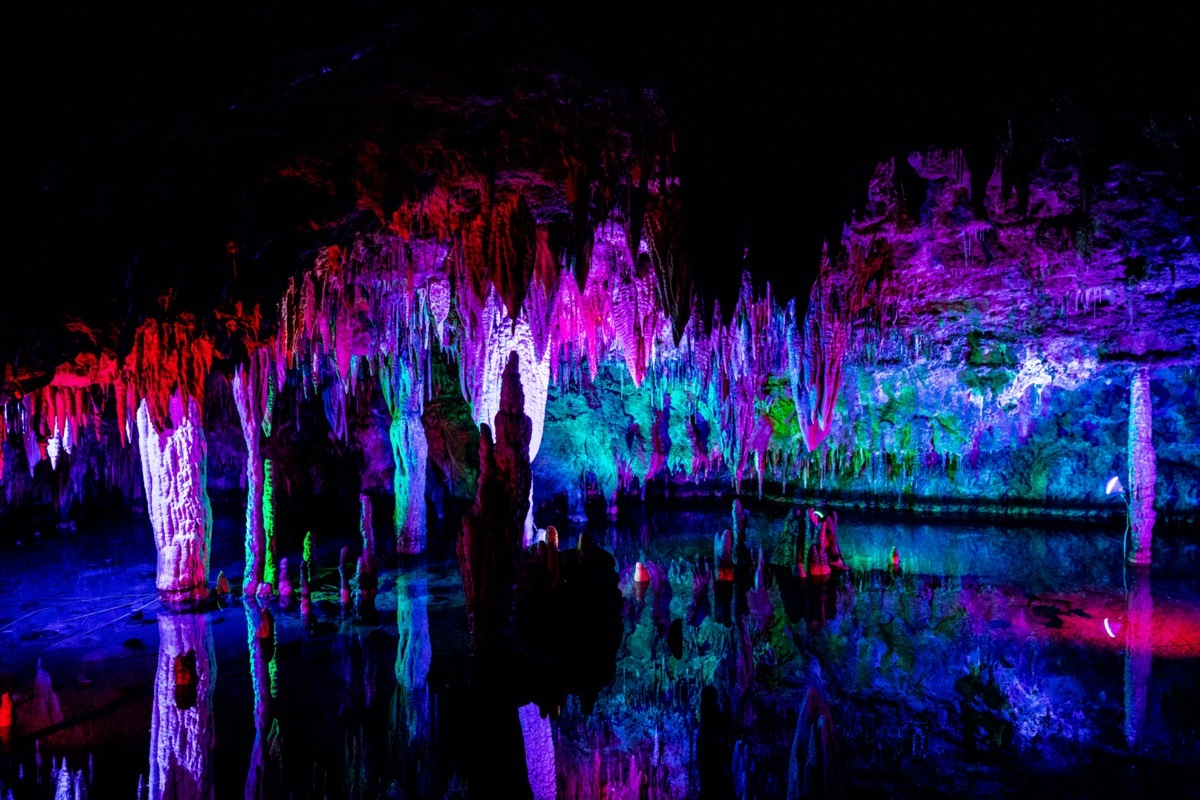 colorful light illuminates the rock formations inside meramec cavern