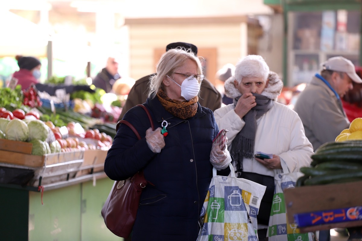 People, with face masks for protection from COVID-19, are shopping vegetables and fruits at marketplace in Sofia, Bulgaria – march 17, 2020.