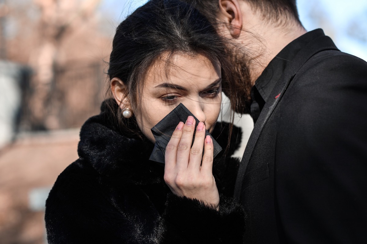 Couple pining after their relative at funeral