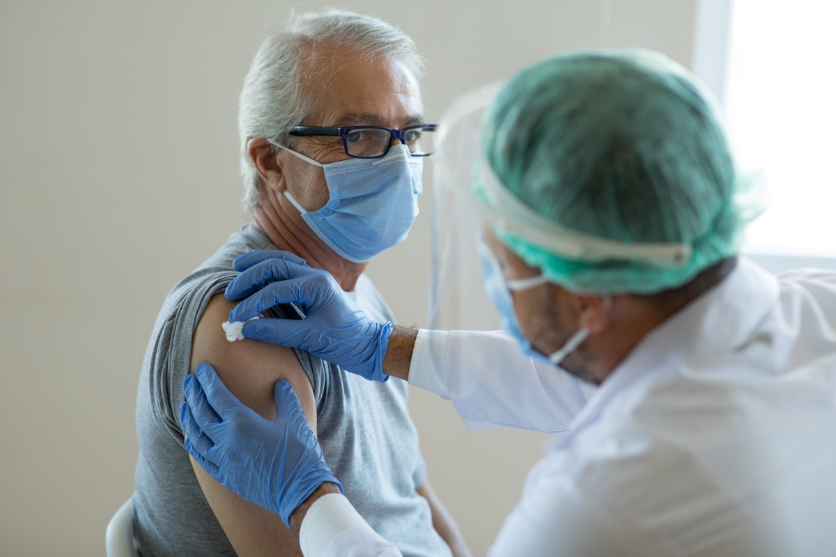 Doctor disinfecting patient's skin for vaccination