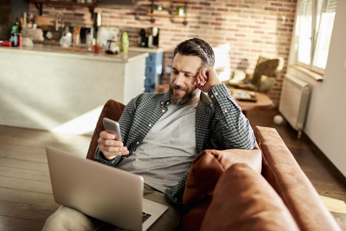 Close up of a young man using a phone at home