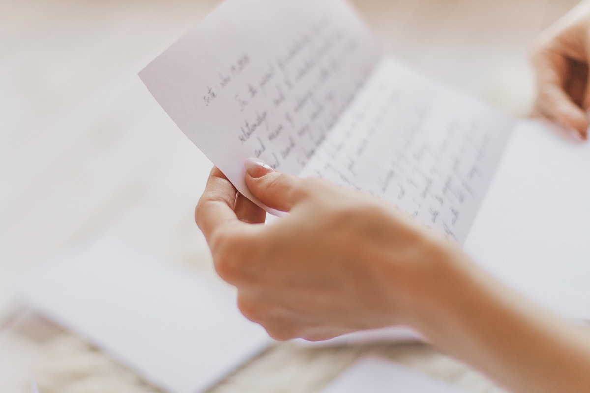 Hands of young woman holding handwritten love letter