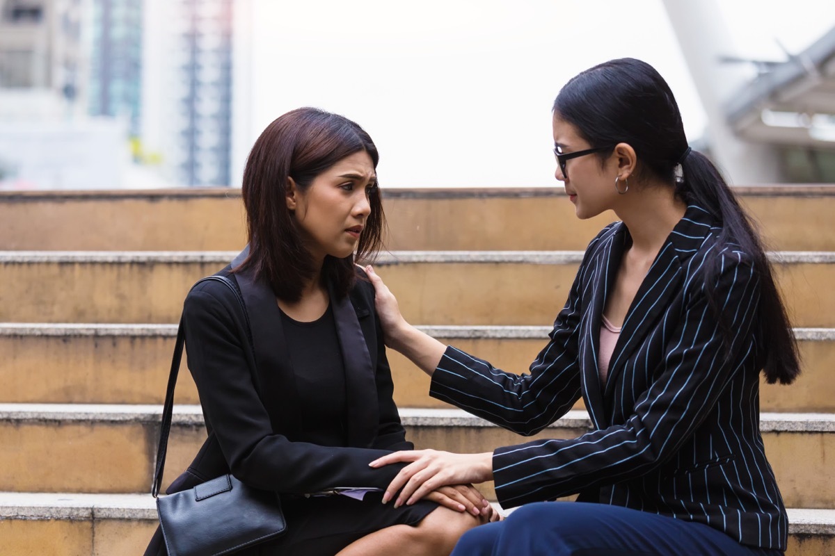 Woman consoling her colleague on the steps outside