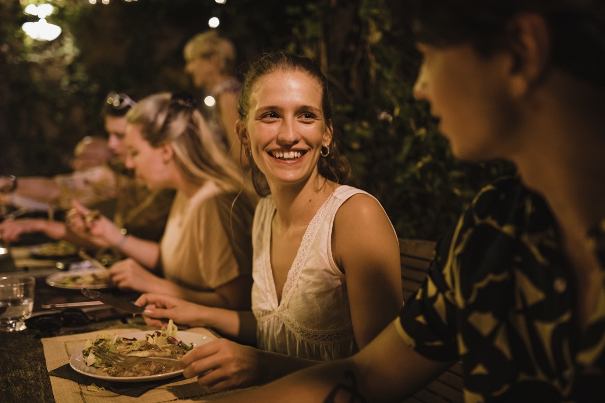 shot of two women talking at a long dinner party table