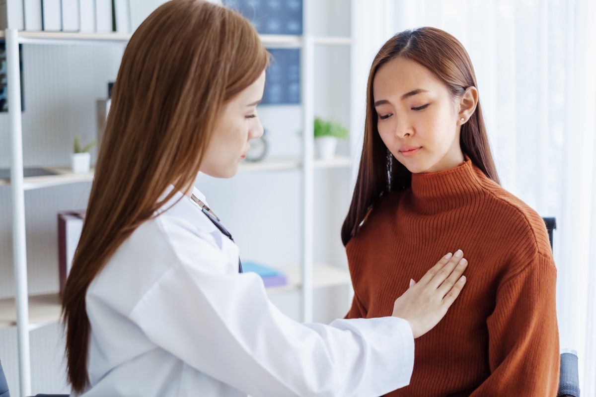 Asian woman getting her breasts examined at the doctor's office