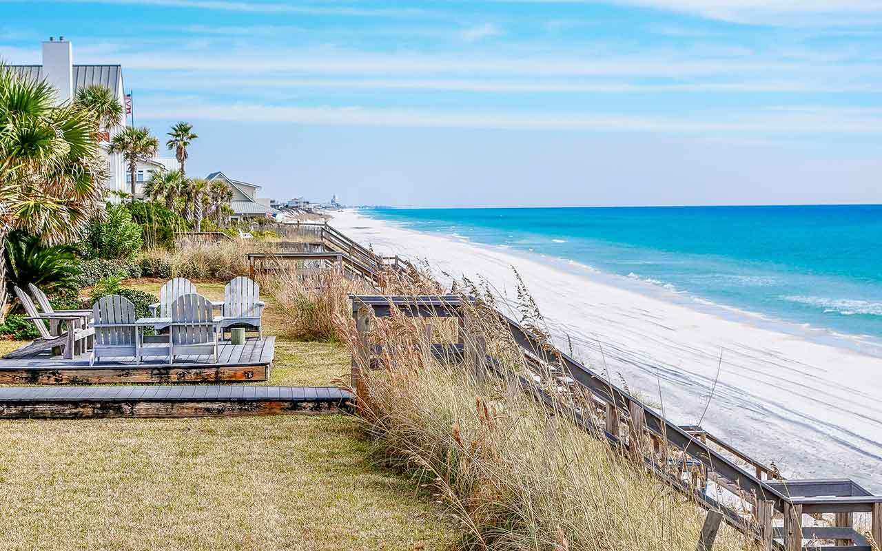 a deck and staircase down to a beach