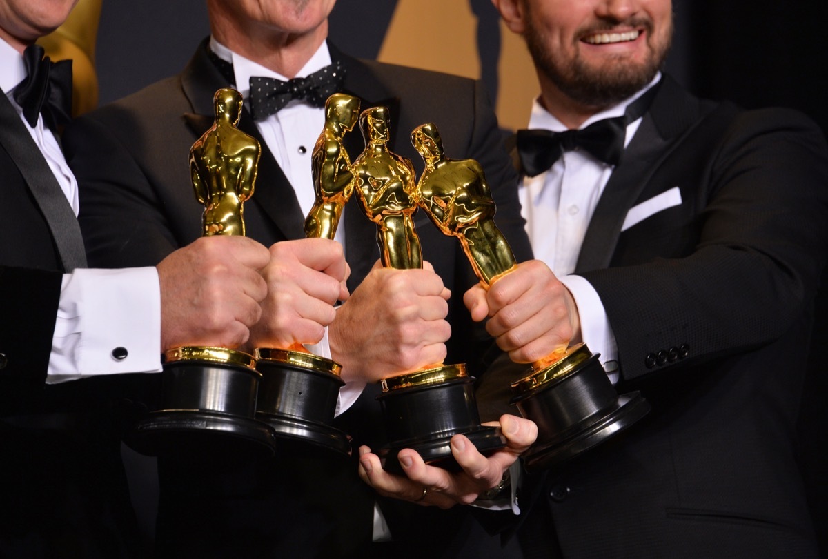 men holding oscars statues