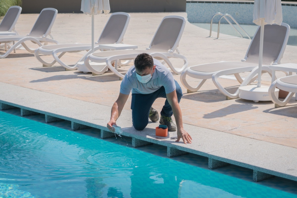 Pool testing kit being used in a swimming pool