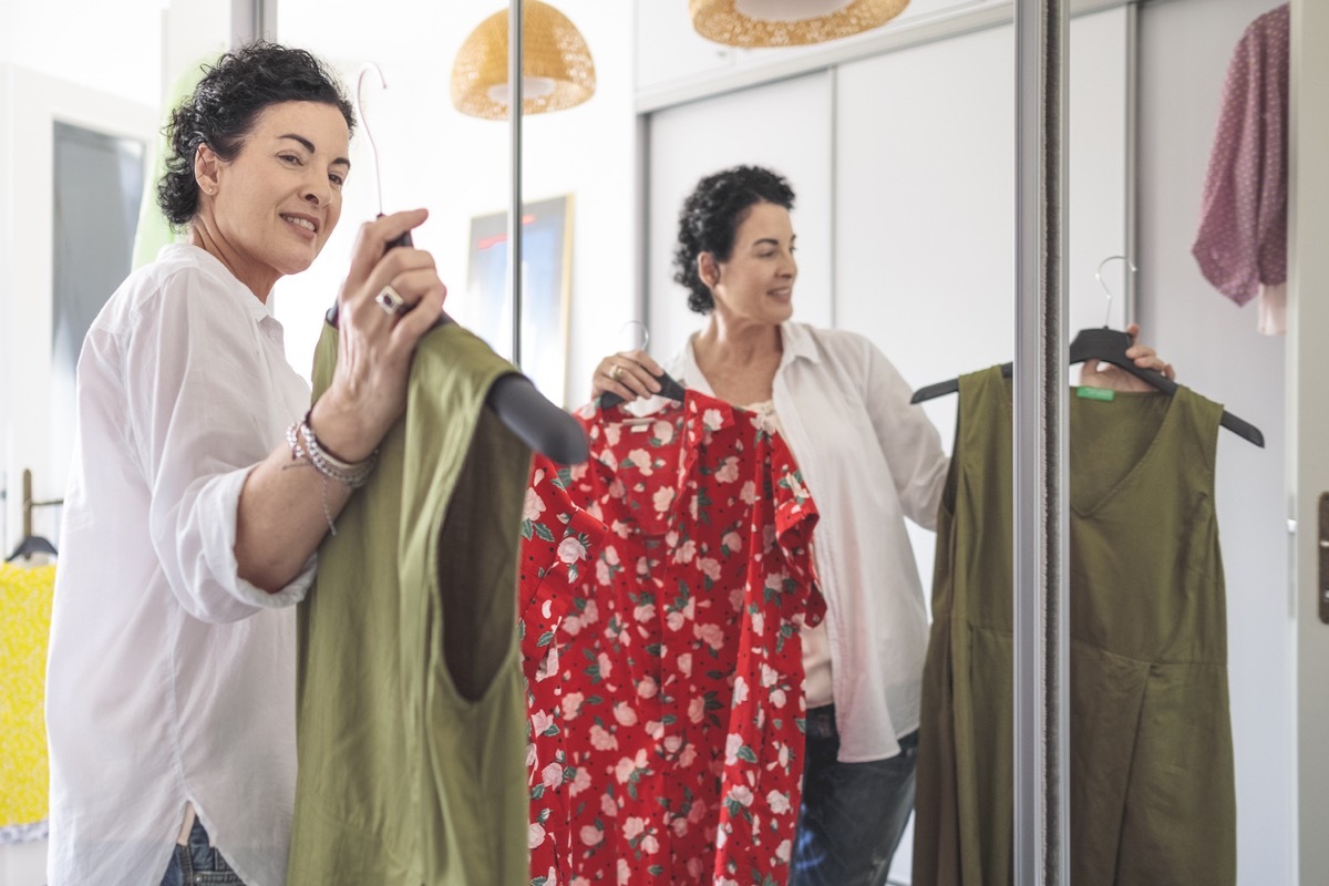 woman looking at clothes in her wardrobe at home