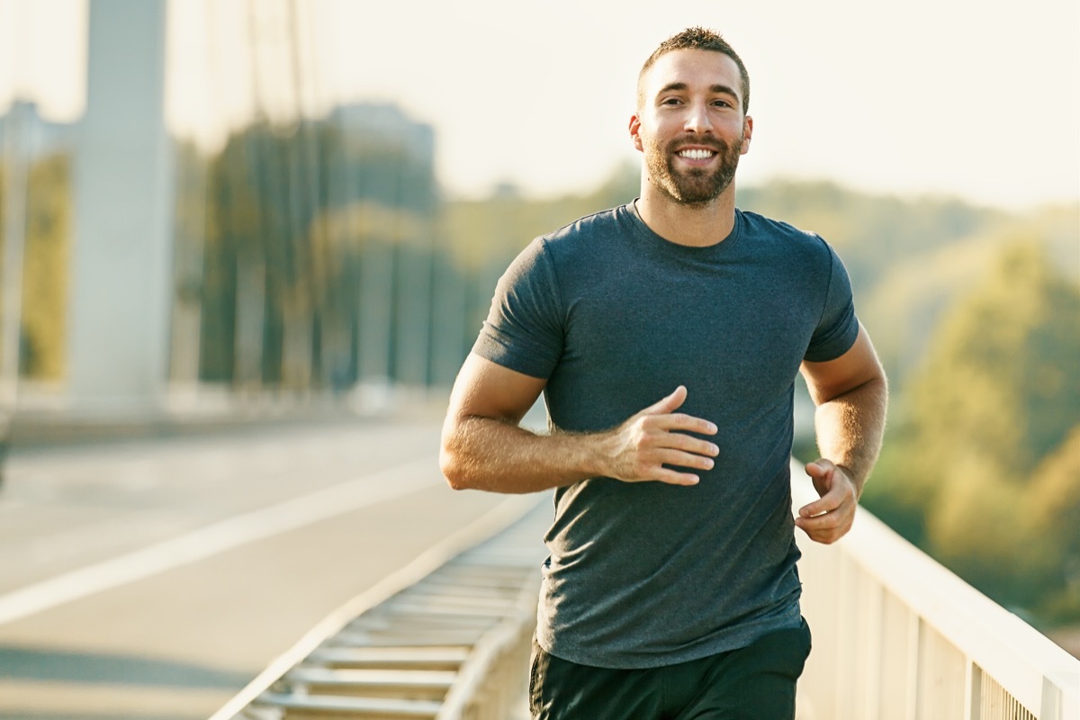 man running alone on the street smiling