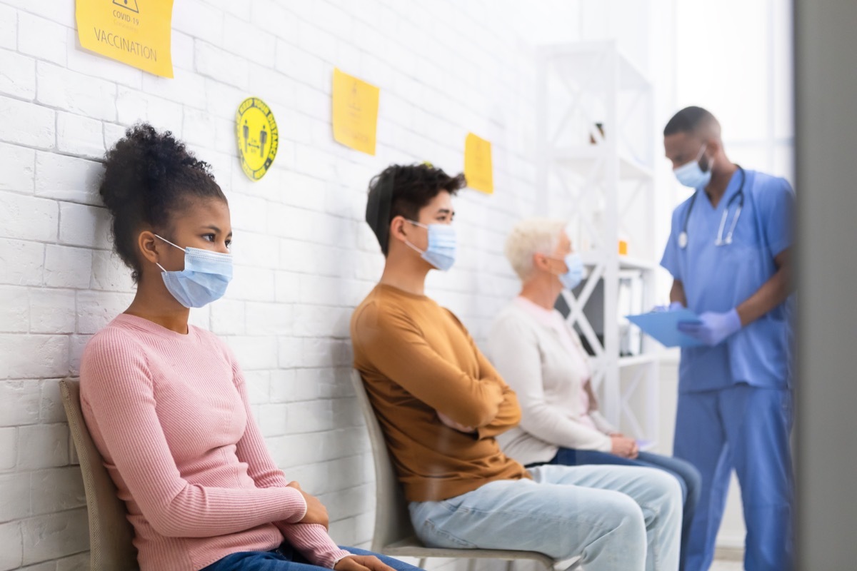 people sitting in doctor's office waiting room wearing masks amid covid