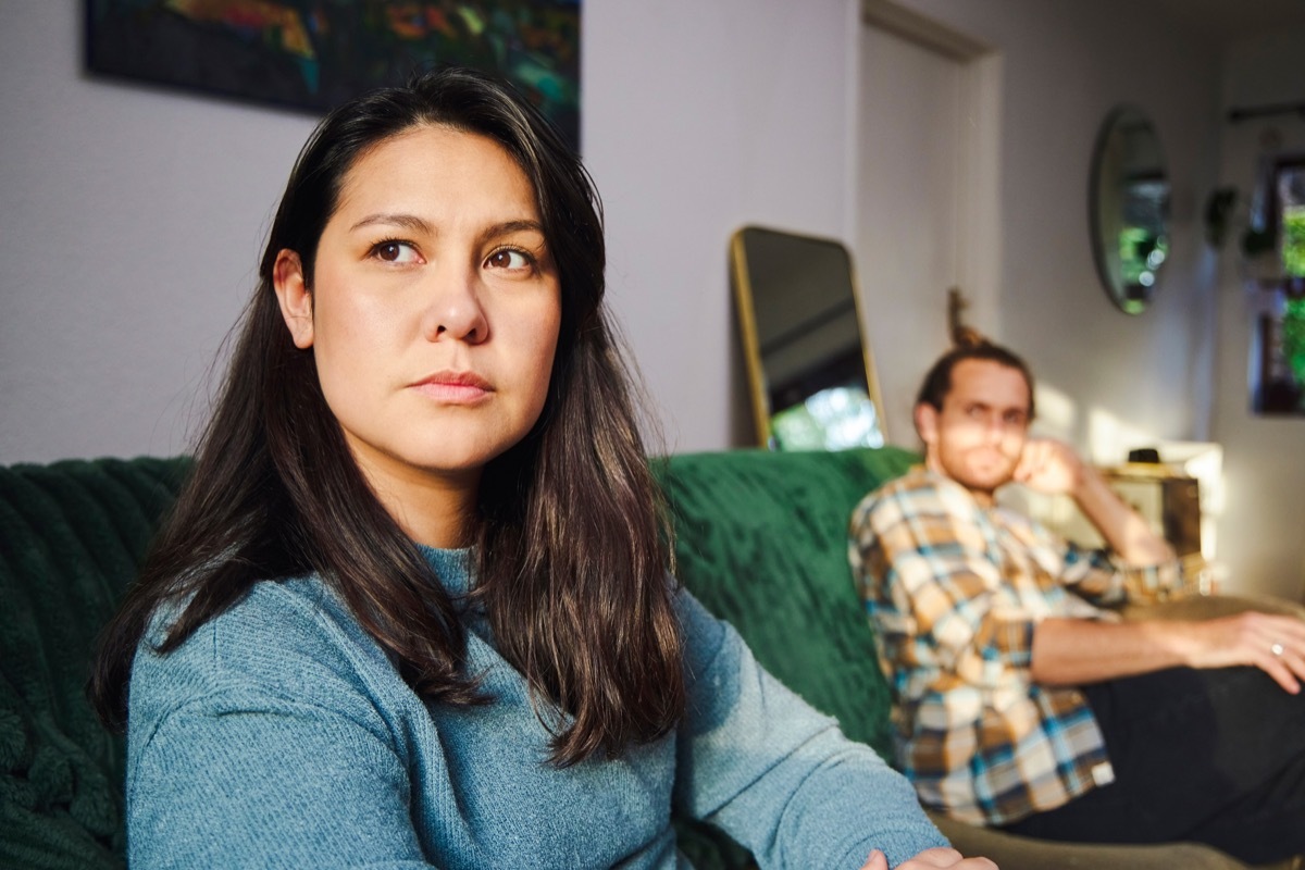 Cropped shot of an attractive young woman looking annoyed after arguing with her boyfriend who is sitting in the background