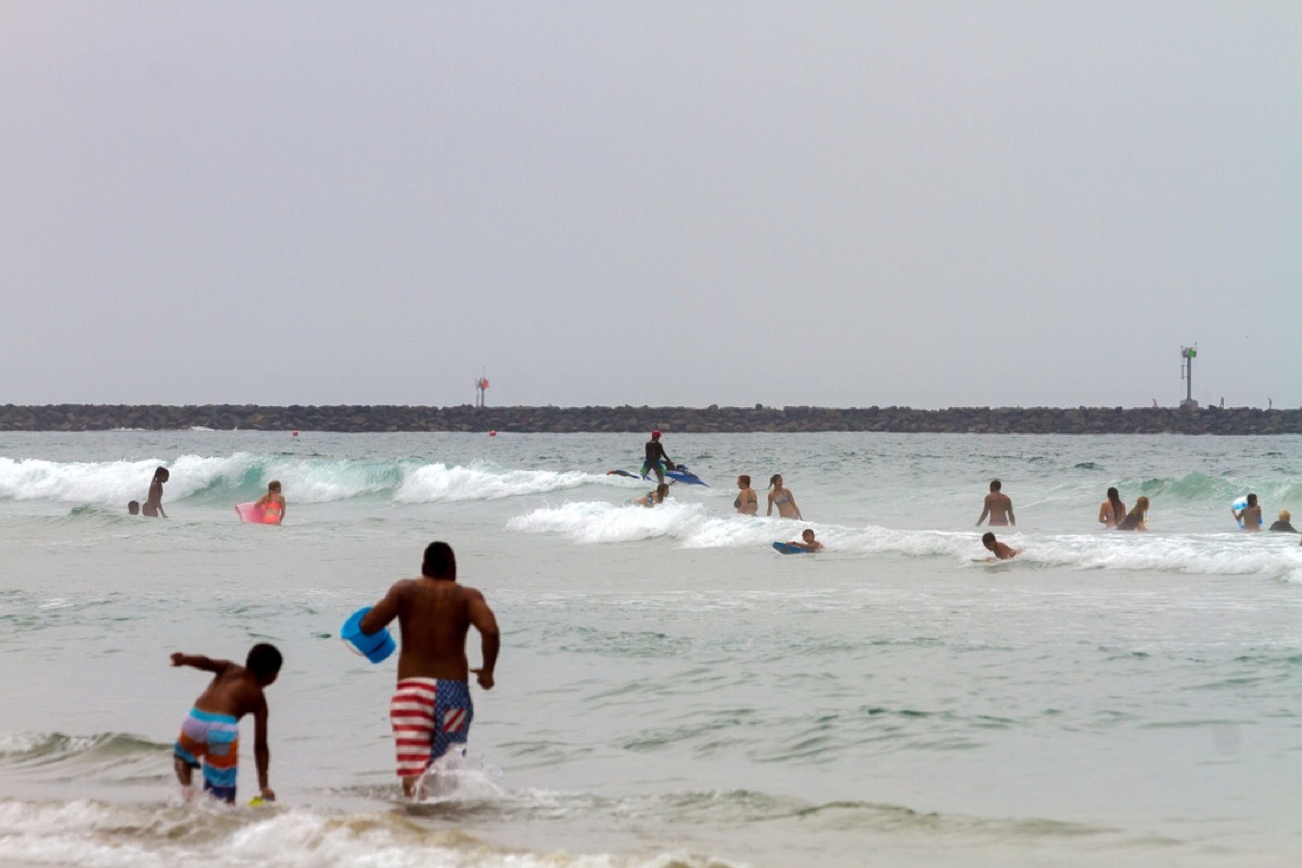 people running into the water at the beach