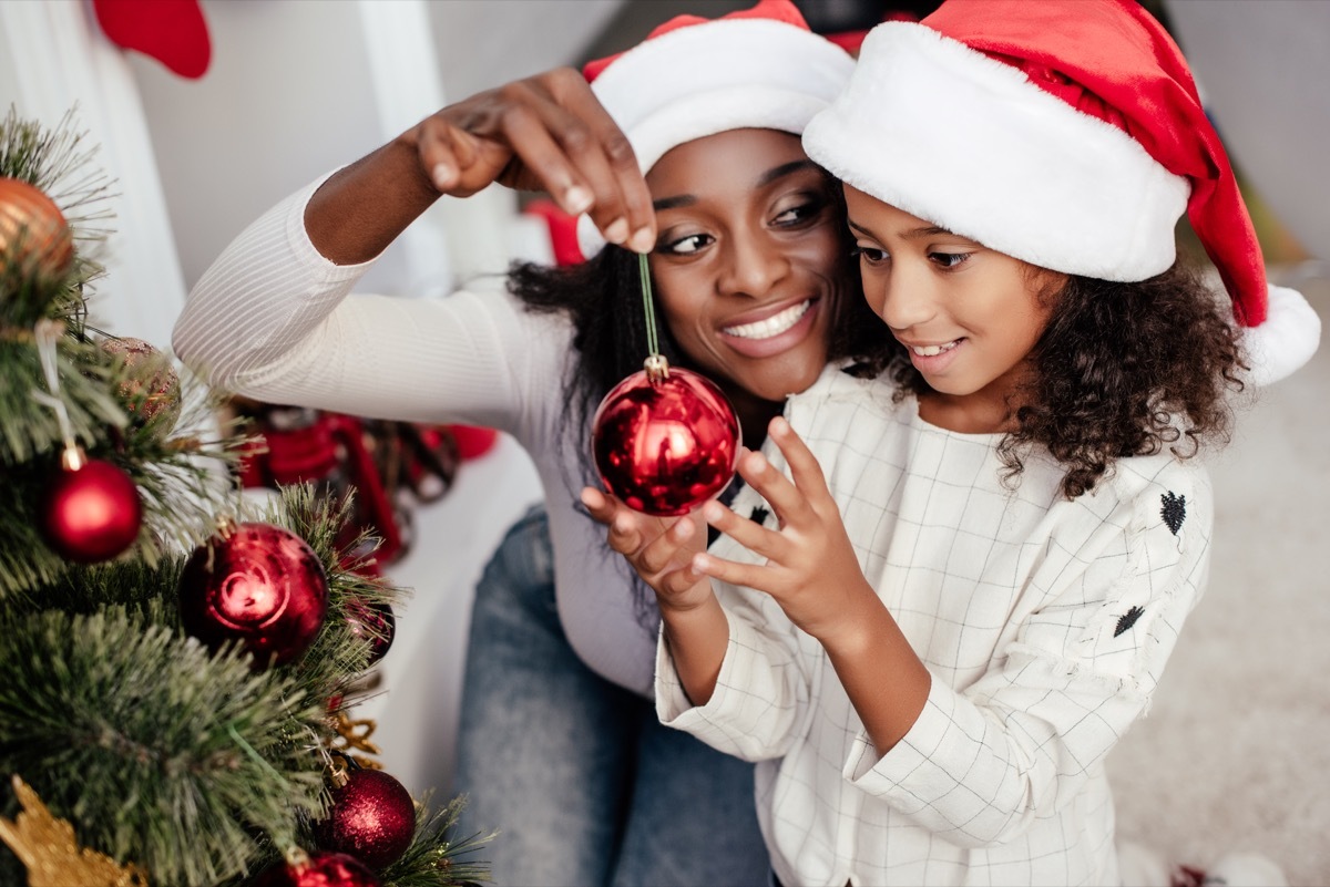 mother and daughter putting up their christmas tree decorations