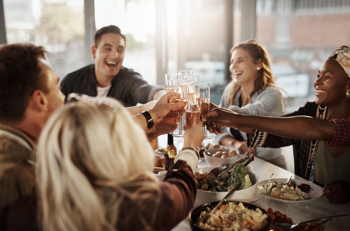 Group of young friends making a toast at a dinner party