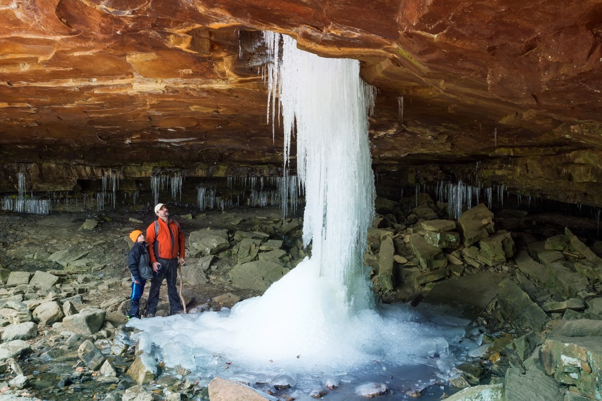 frozen waterfall comes through a hole in the rock