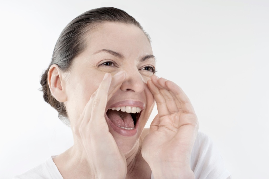 Mature woman shouting and screaming isolated over white background