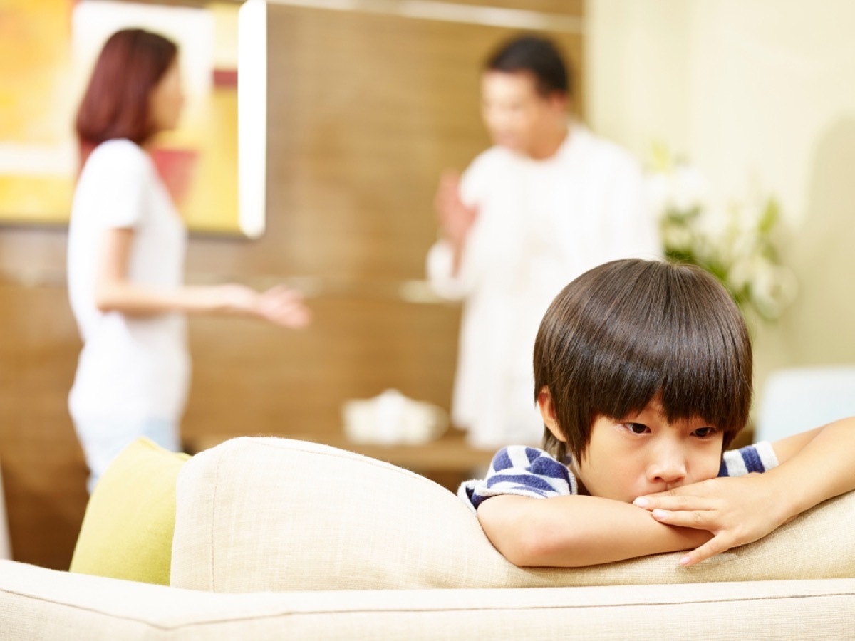 sad boy with parents fighting in the background, parent divorce