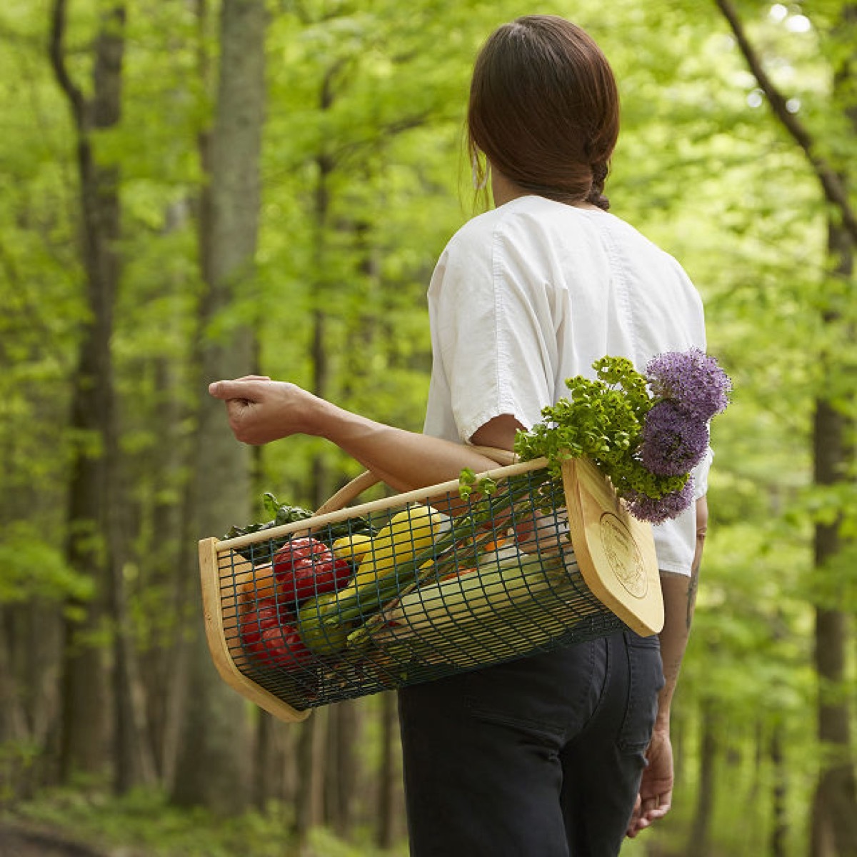 woman carrying veggies in harvest basket