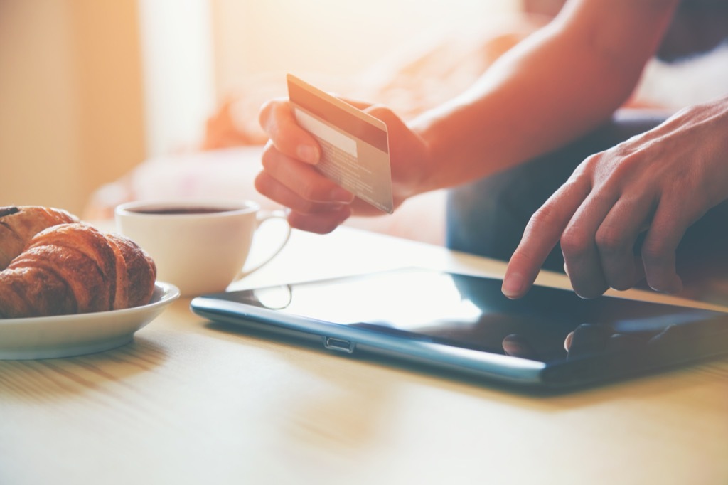 hands holding a credit card shopping online with a tablet