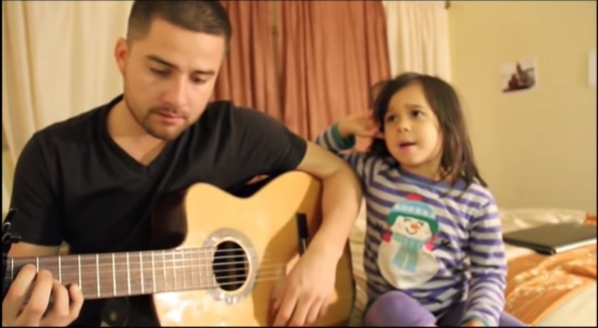 young man playing acoustic guitar next to young girl