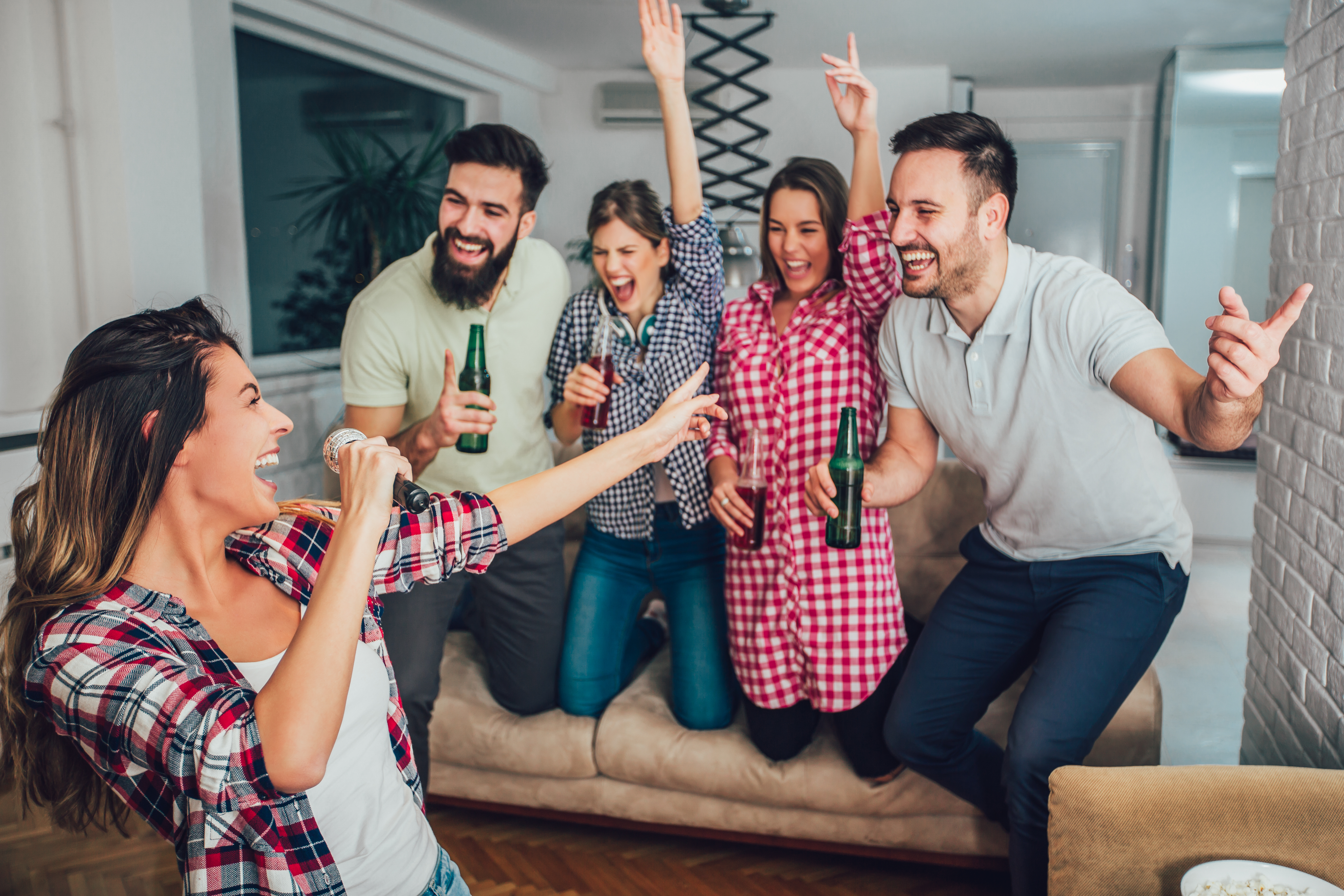 group of friends drinking beers and doing karaoke