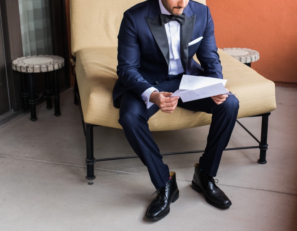 Groom reading wedding card or letter 