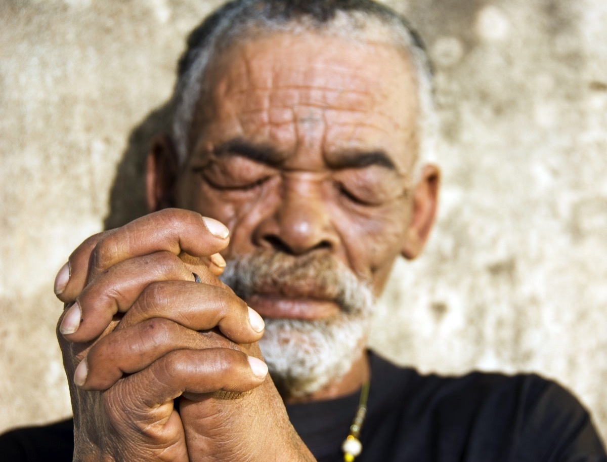 older black man standing up with eyes closed