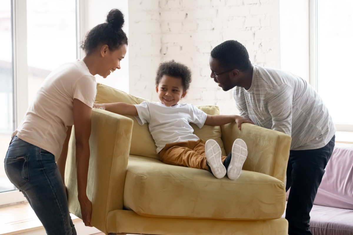 young couple moving furniture with son