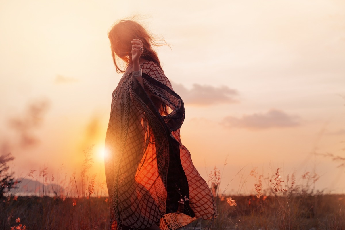 Woman dancing in a beautiful golden field. 