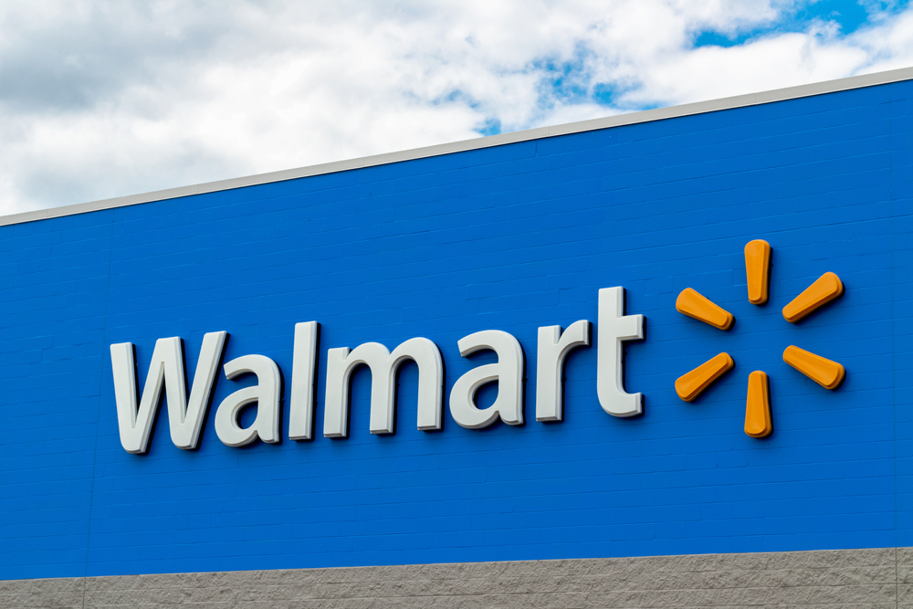 A Walmart sign in front of the store on a blue background