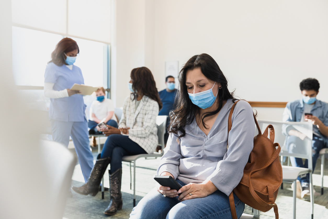 Woman sitting in the waiting room of a doctor's office.