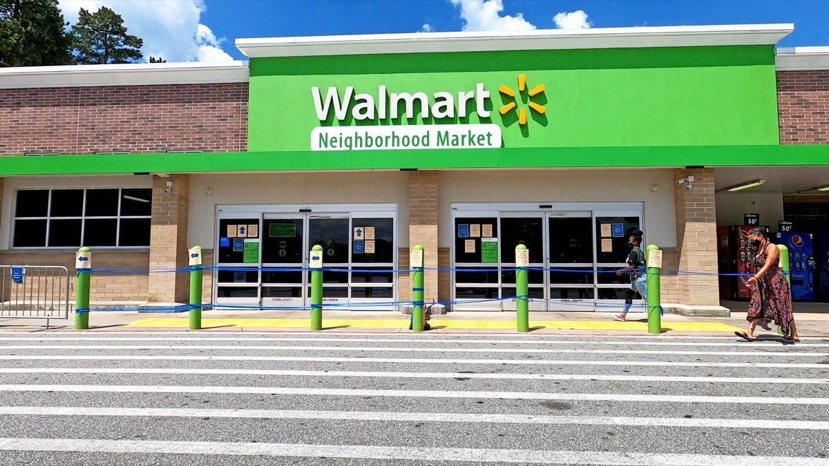 Two females wearing face masks as they enter a Walmart Neighborhood Market