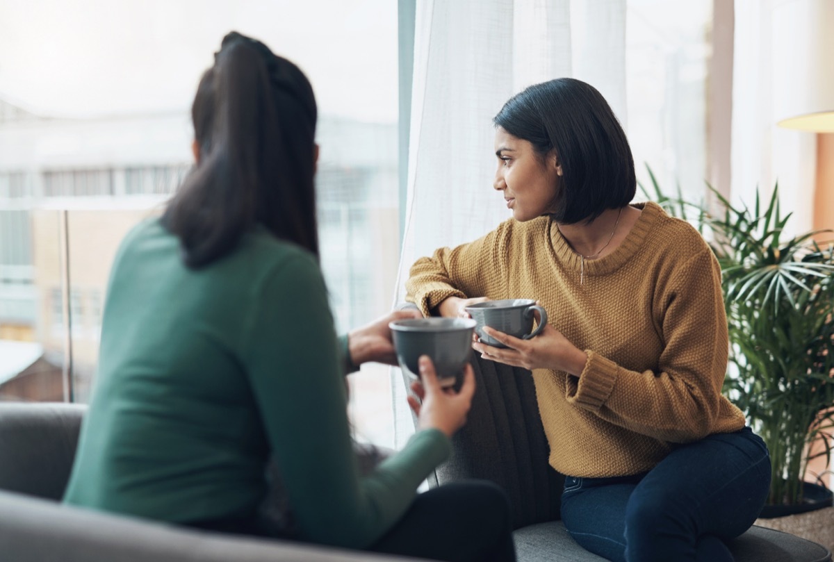 Shot of two young women drinking coffee while sitting together at home