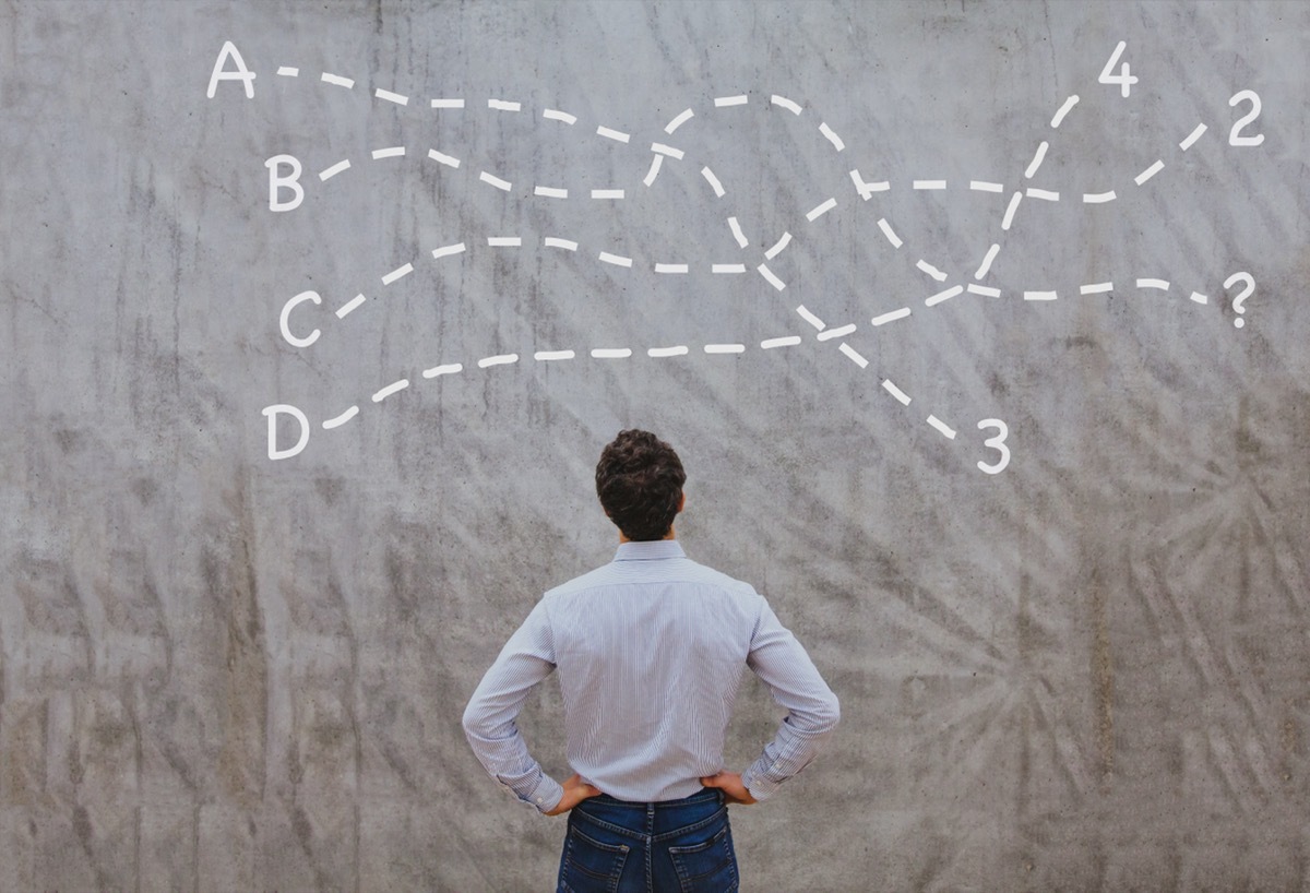 man looking at a chalkboard with a complicated equation written on it