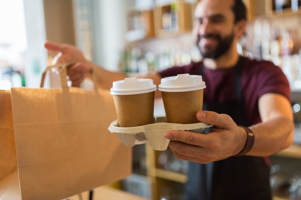 Barista handing over two cups of coffee