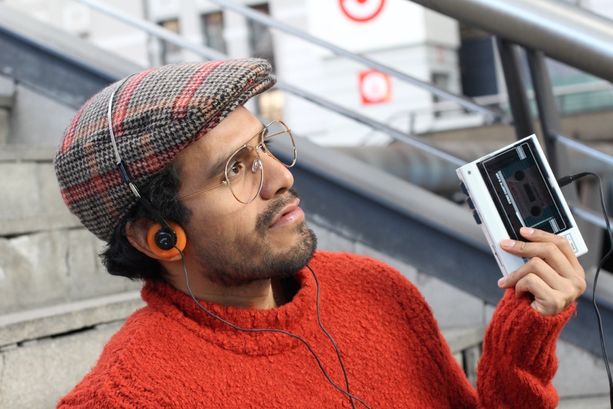 Retro-looking man listening to music on a old school tape recorder