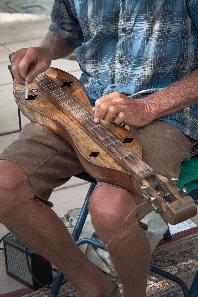 man playing dulcimer instrument, hard state facts