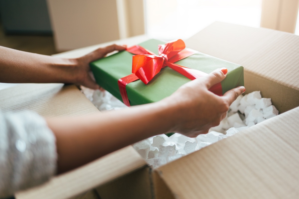 Close up of woman hands opening parcel with present box.