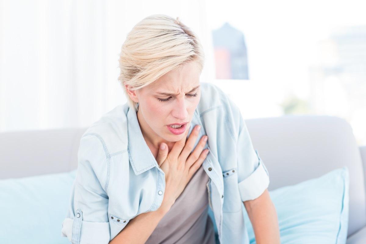 Woman having breath difficulties in the living room - Image