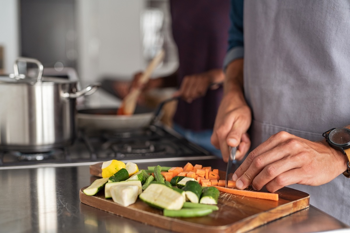 closeup of hands slicing carrots