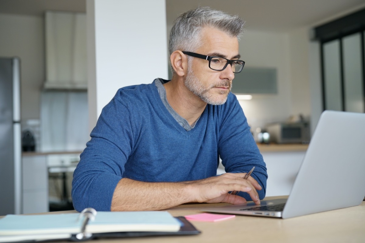 Middle-aged man working from home-office on laptop