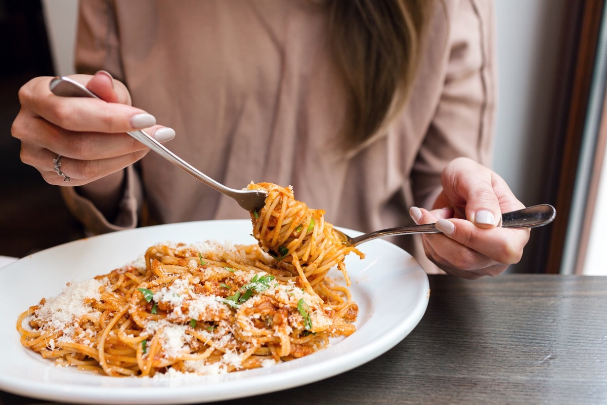 woman's hands, eating spaghetti in a bowl