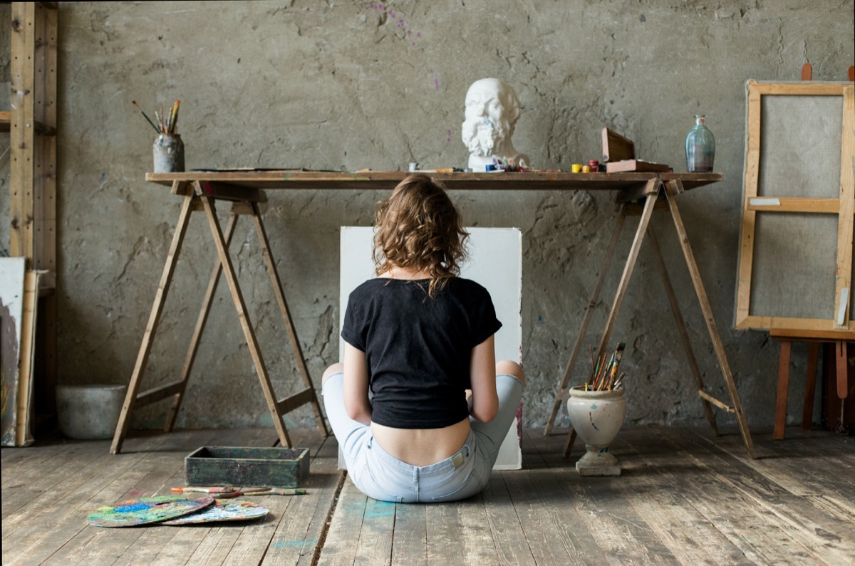 Woman painting sitting on floor