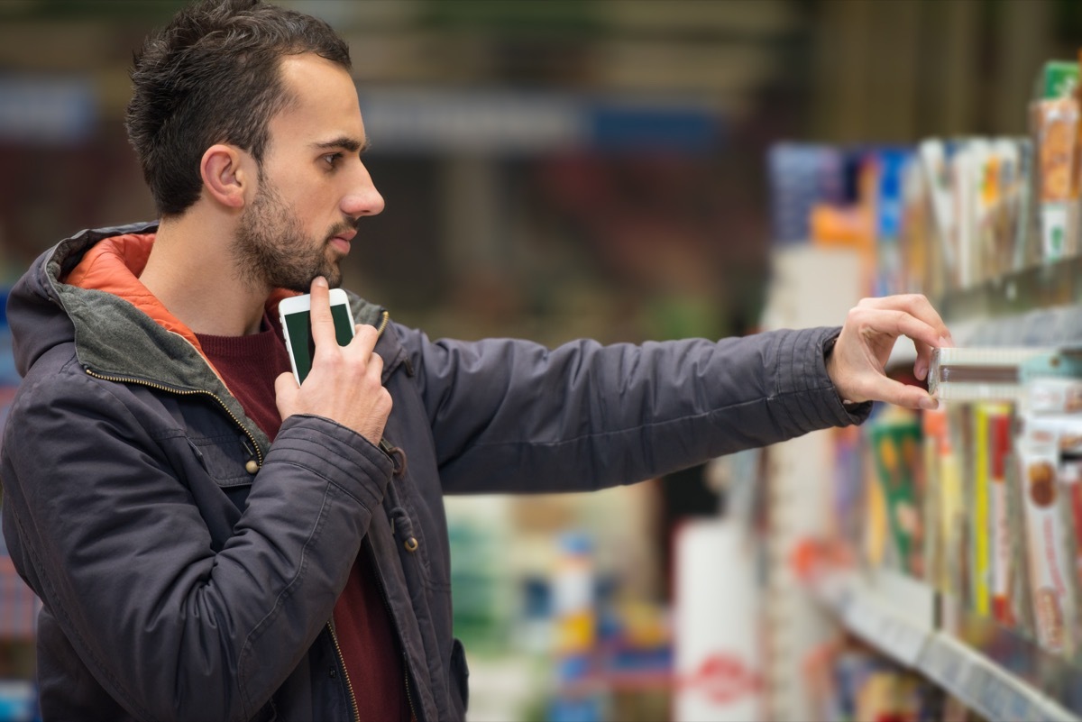 young white man putting item back on the wrong shelf while shopping in store