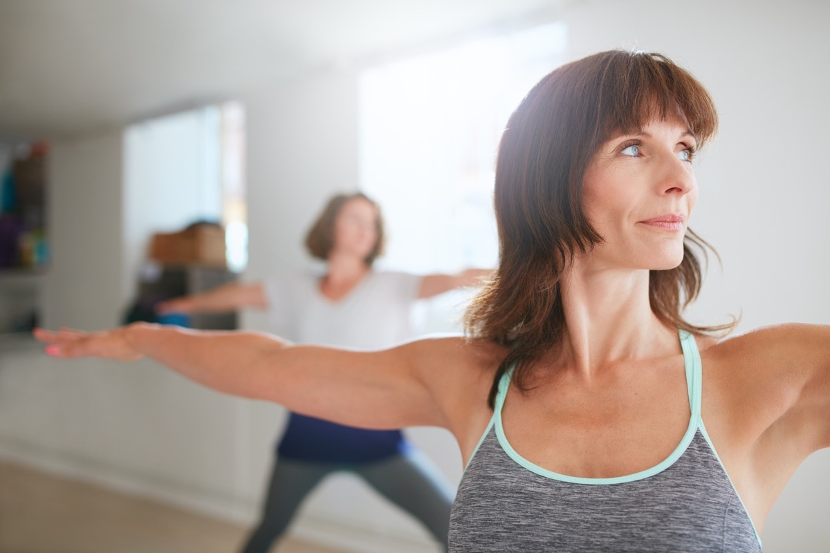 Woman doing warrior pose in yoga class