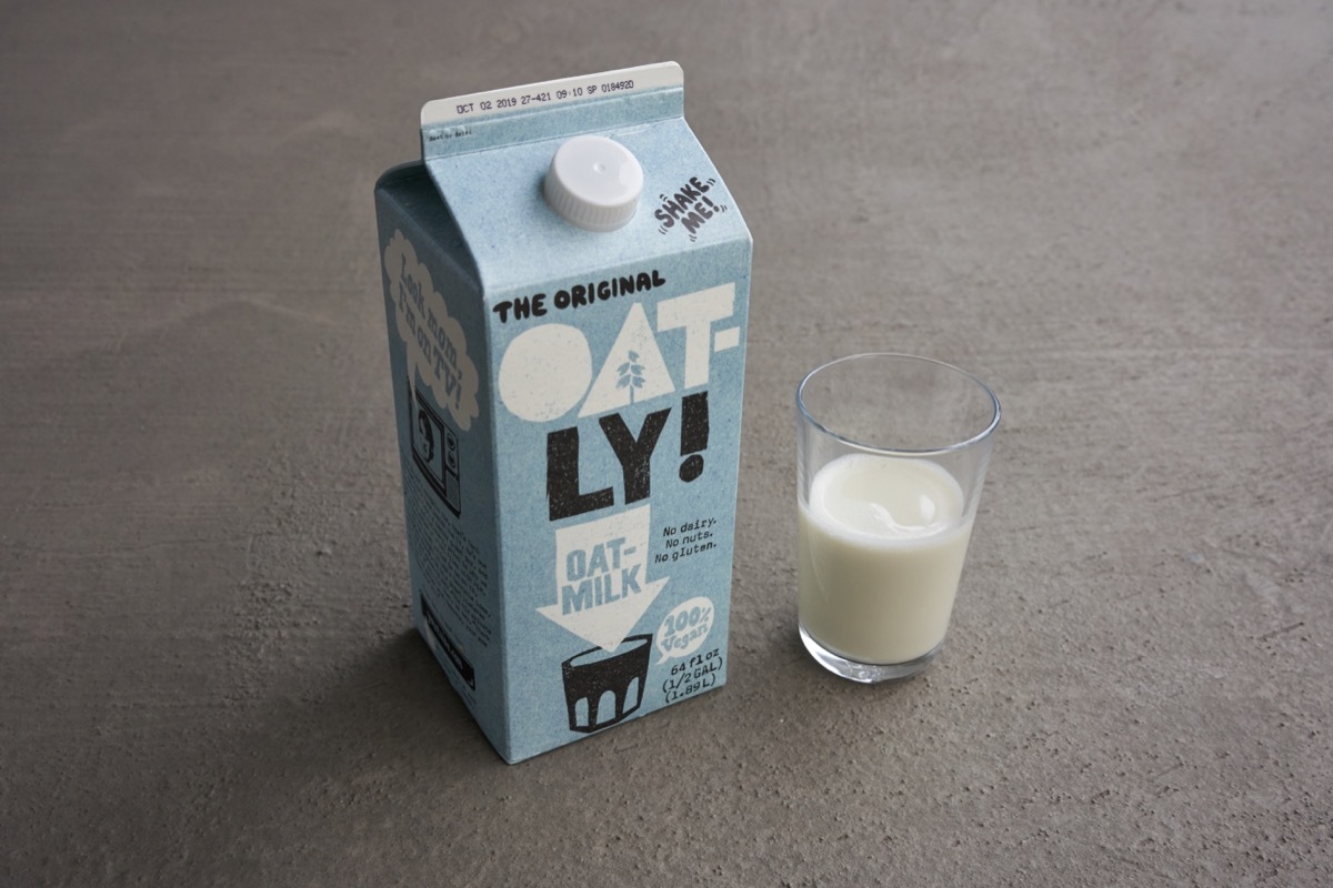 oatly oat milk, light blue milk carton, glass of milk