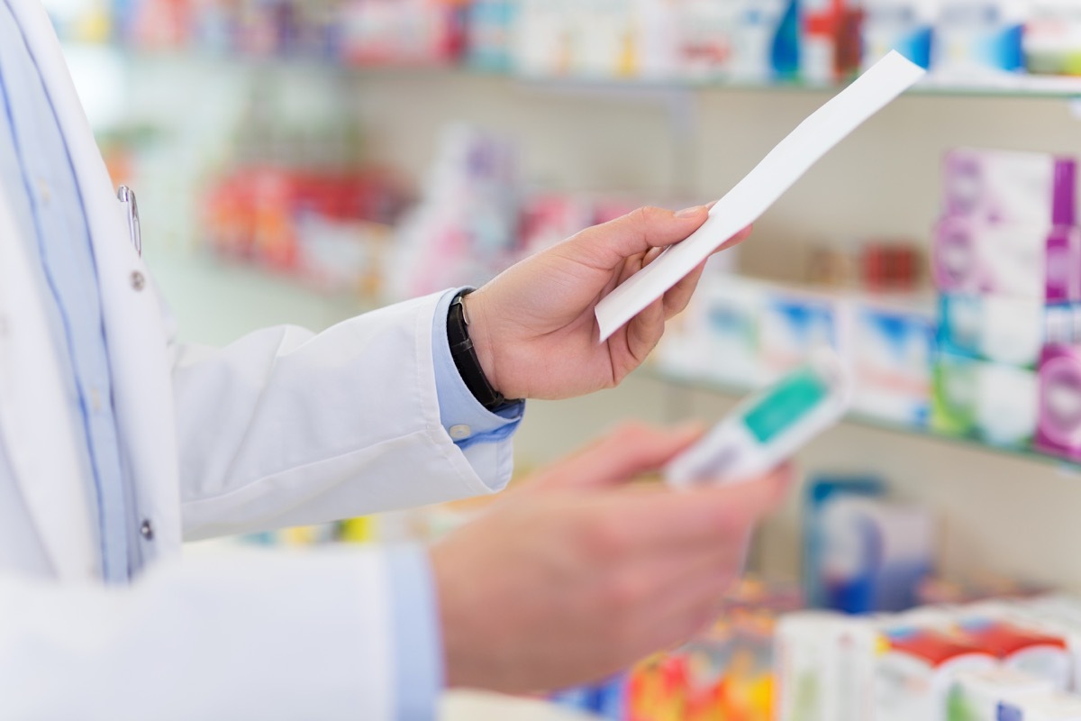 Close up of pharmacist's hand filling prescription in pharmacy