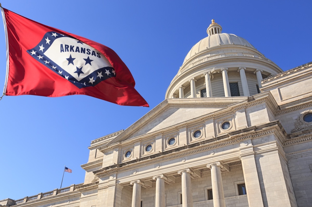 Arkansas flag flying high beside the State Capitol Building